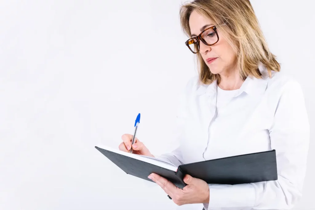 a woman holding a pen and a notebook conducting a business valuation