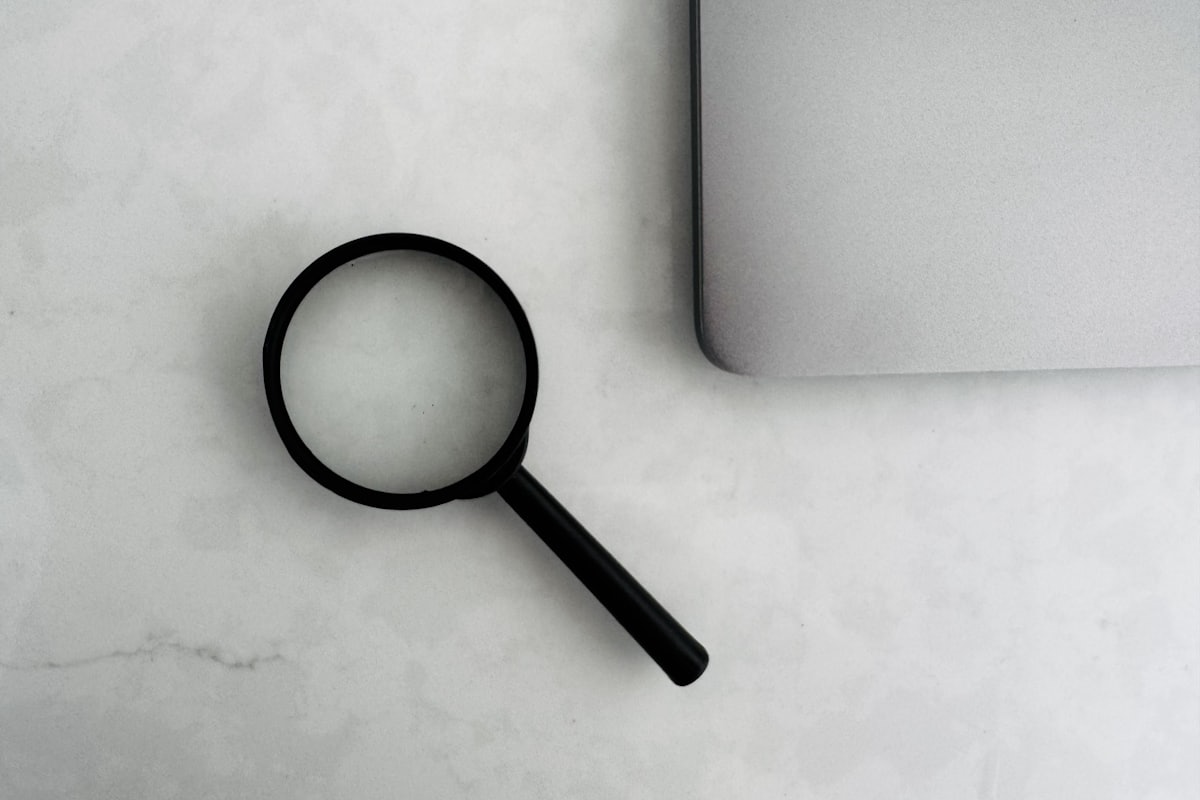 Magnifying glass beside a laptop, representing buyer due diligence