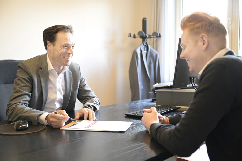 Advisor and business owner reviewing valuation documents together at an office desk
