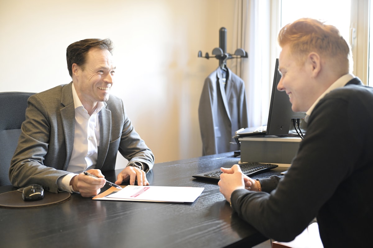 Advisor and business owner reviewing valuation documents together at an office desk