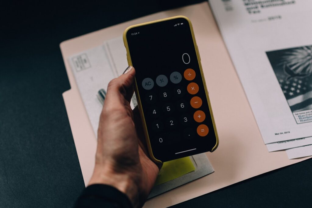 Reviewing financial paperwork and a calculator to build an add-back schedule
