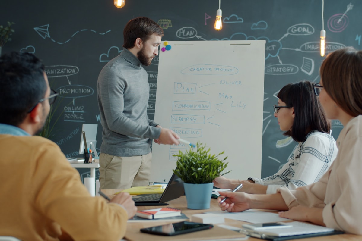 Team reviewing documents together around a whiteboard before a sale