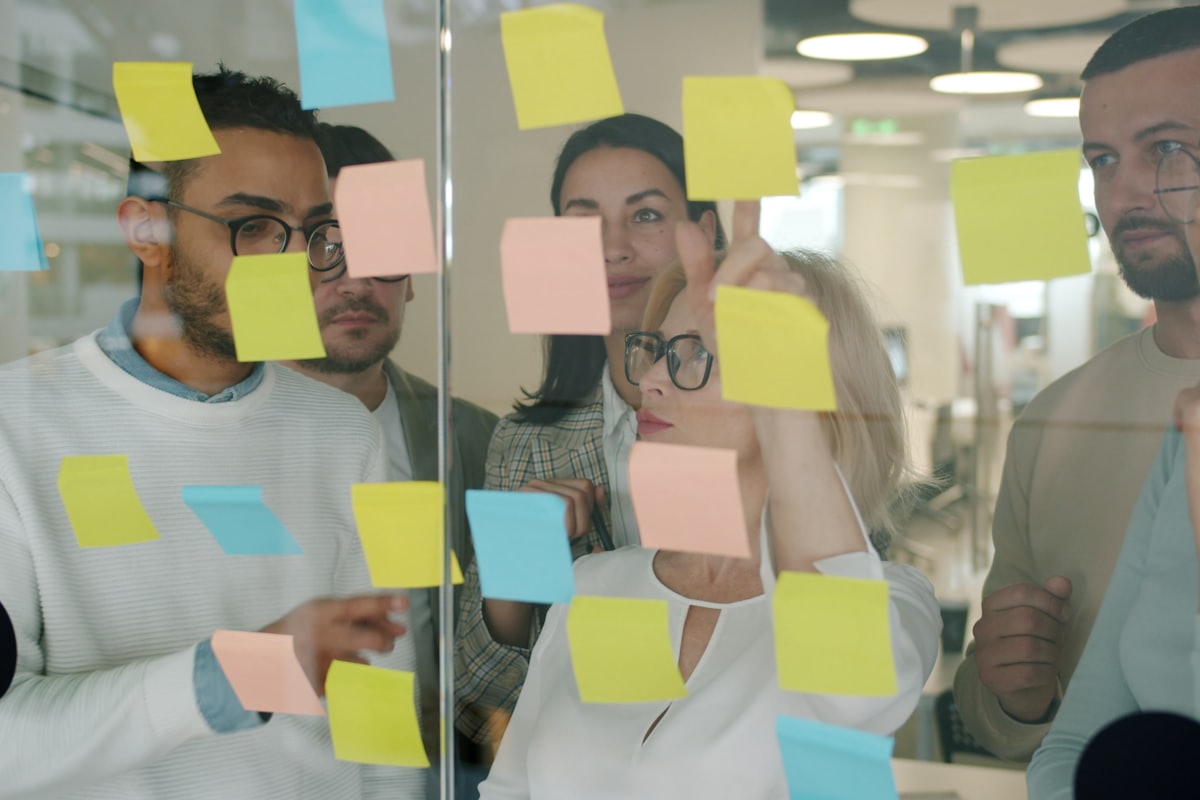 Team mapping out customer accounts on a glass wall with sticky notes