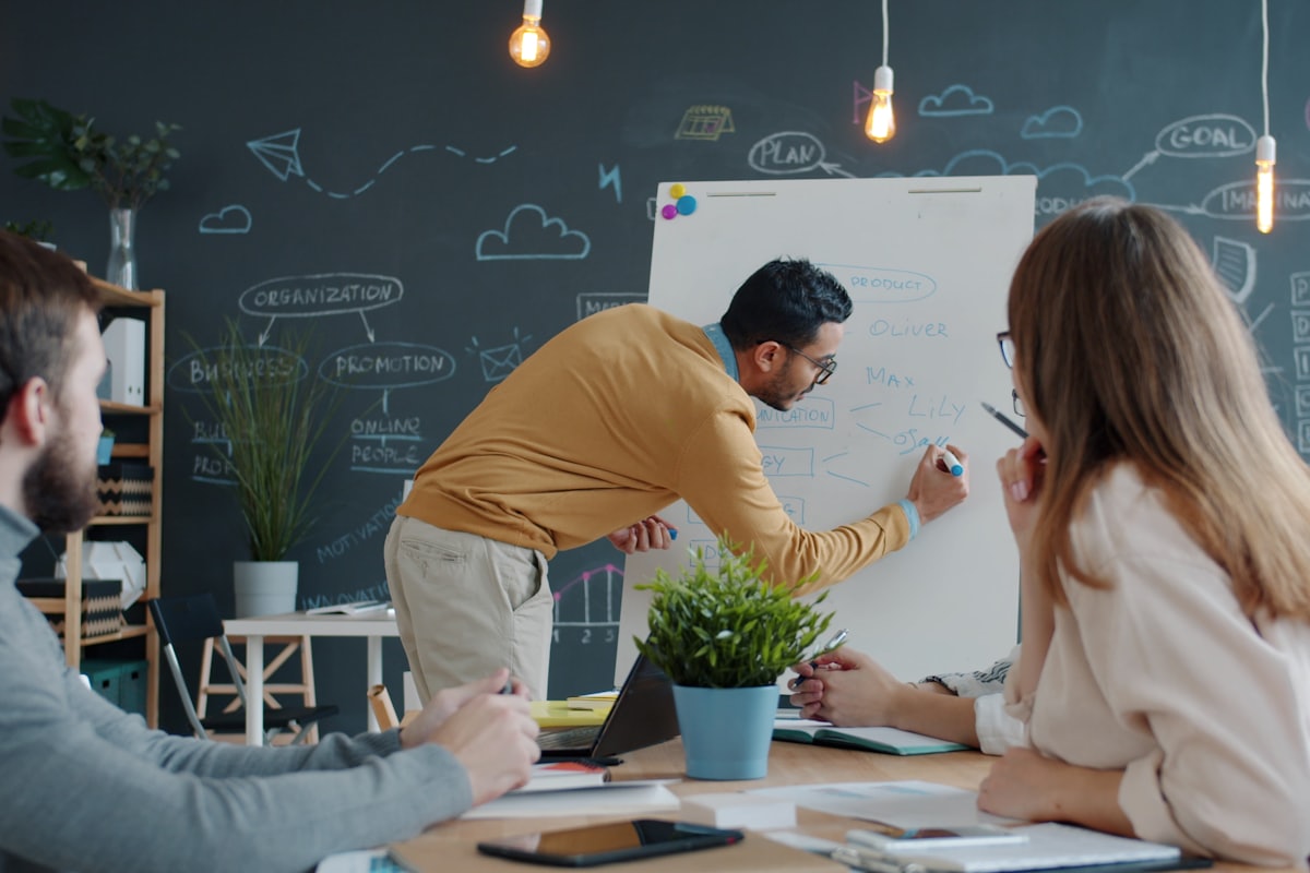 Advisor explaining a valuation calculation on a whiteboard to colleagues
