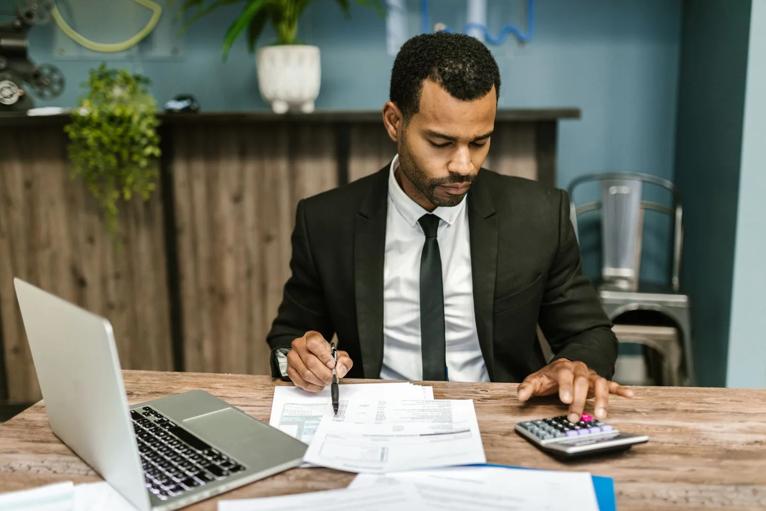 Business owner reviewing SDE and EBITDA calculations Business owner reviewing SDE and EBITDA calculations with a calculator and financial documents