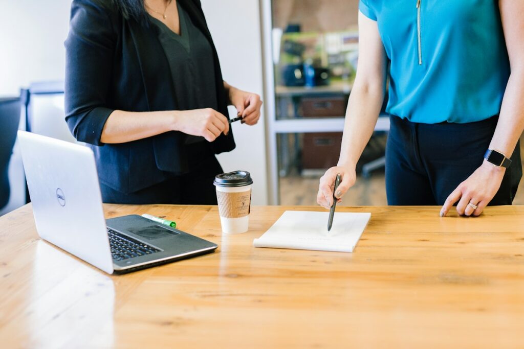 Two business professionals reviewing information together on a laptop