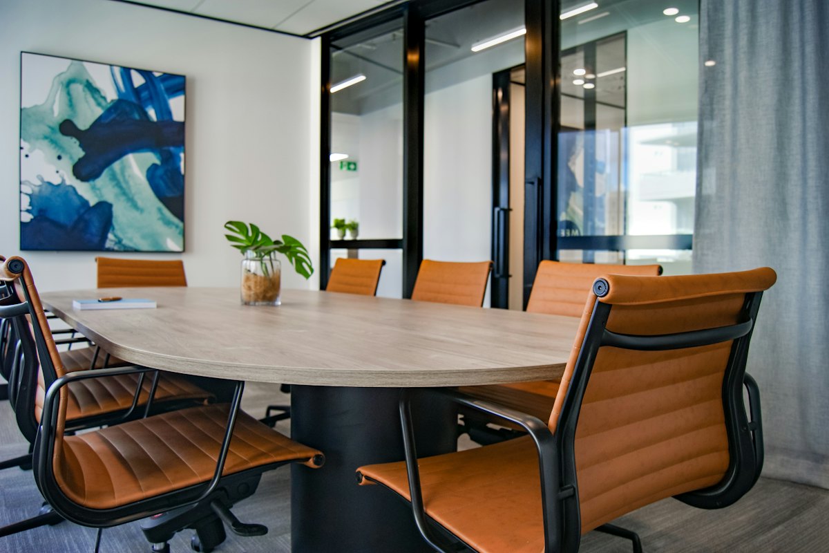 Business owner reviewing SDE and EBITDA calculations Modern empty boardroom with glass walls and daylight