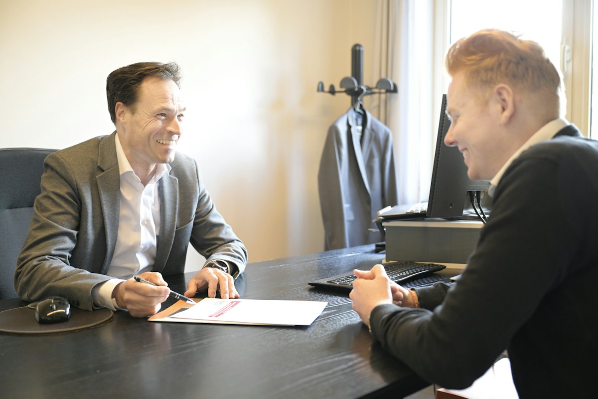 Business advisor and owner reviewing documents together across a desk