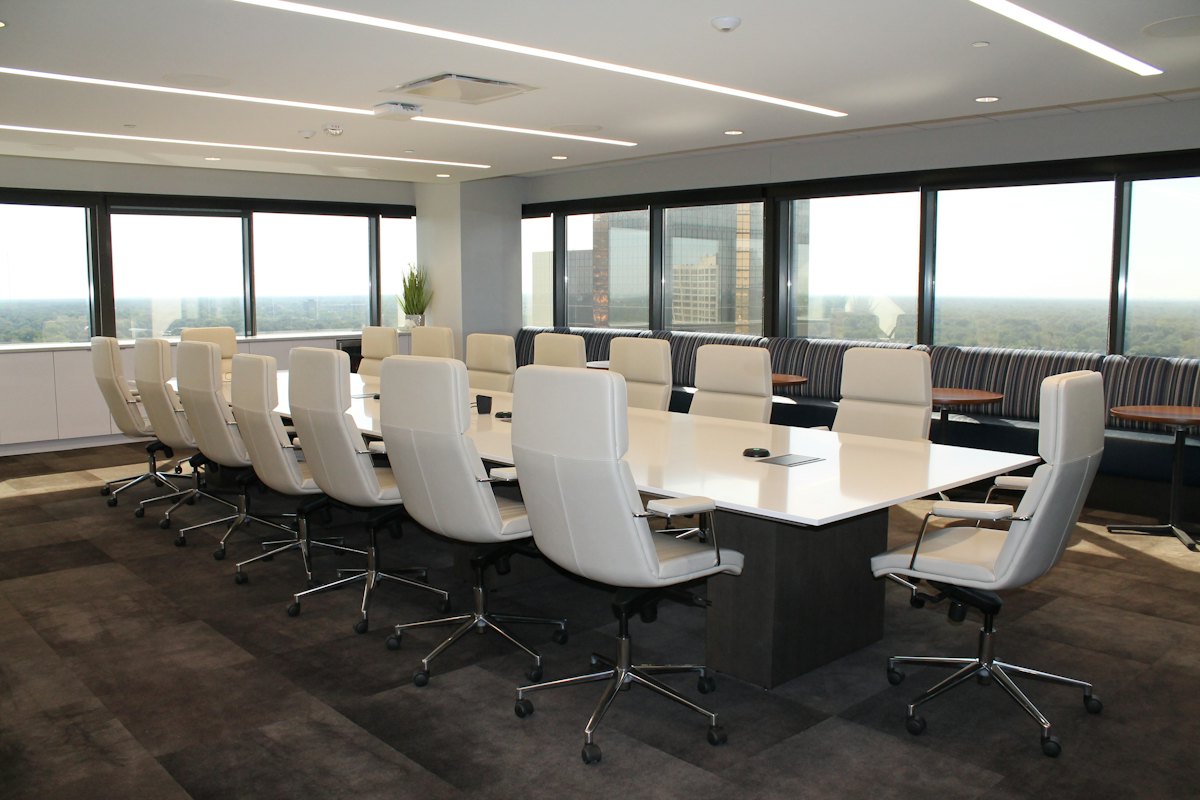 Long empty boardroom table in a bright corporate office