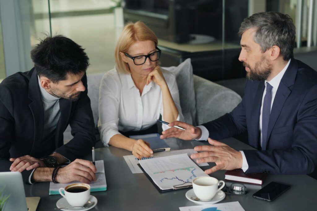 Professionals in suits reviewing financial charts at a conference table
