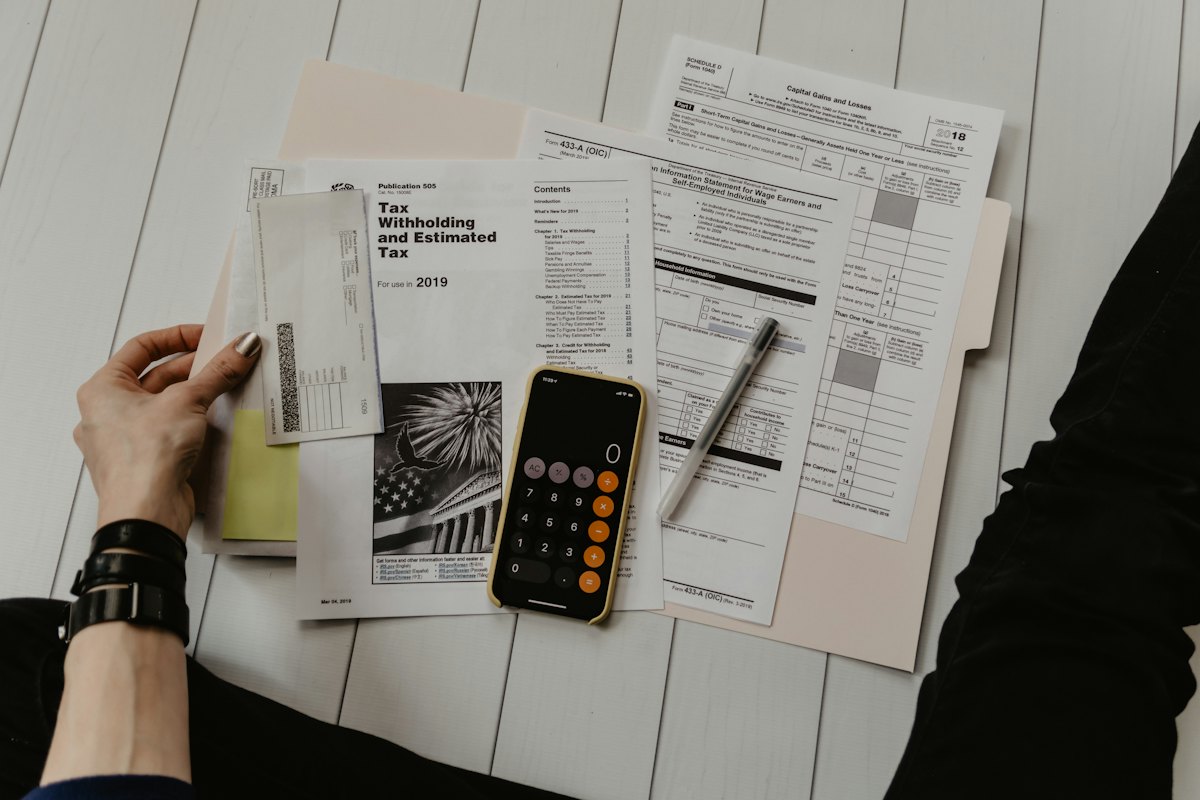 Business owner reviewing SDE and EBITDA calculations Desk with financial documents, calculator and notes