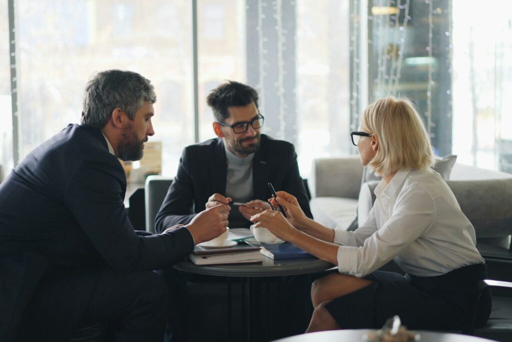 Business owner meeting with two advisors to plan an exit timeline