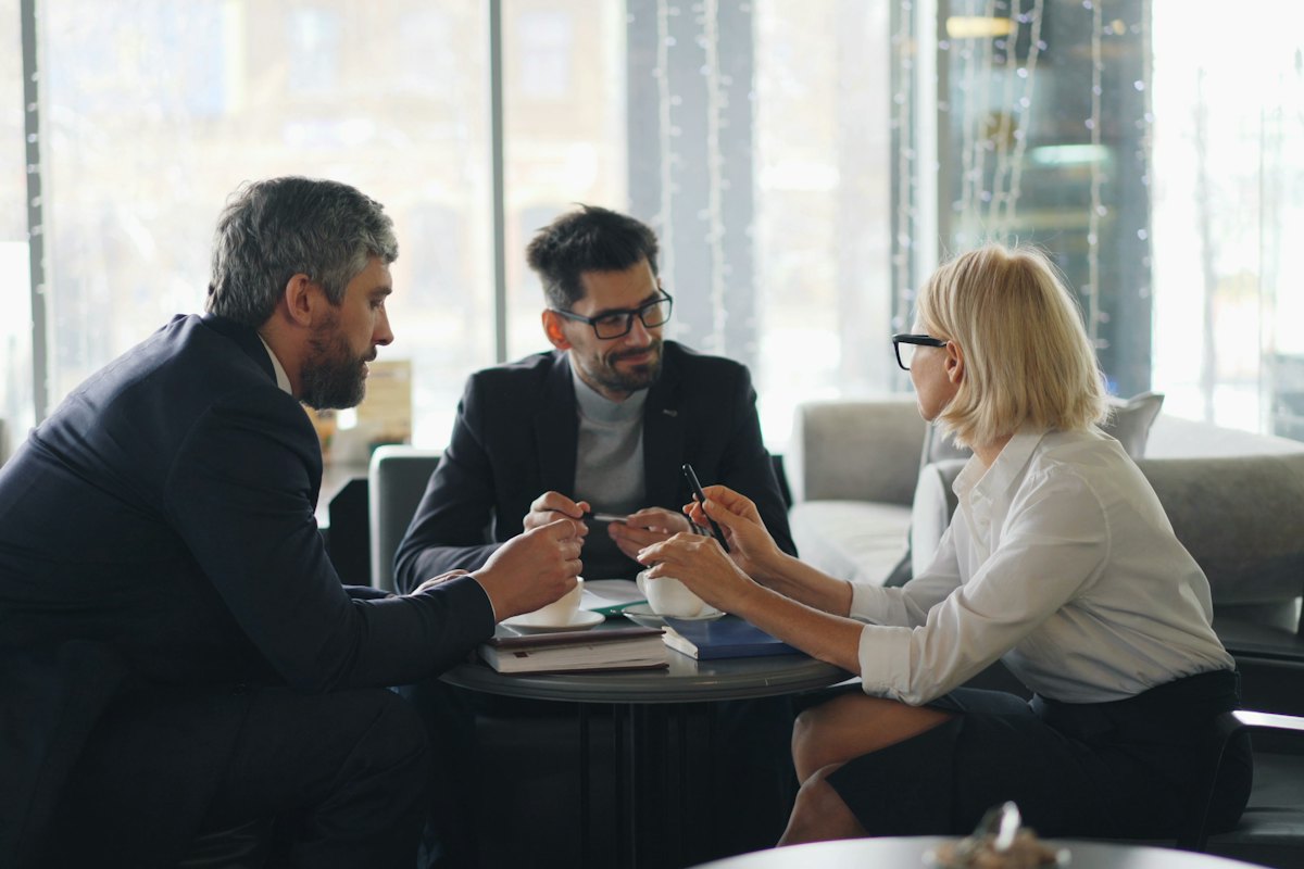 Business owner meeting with two advisors to plan an exit timeline