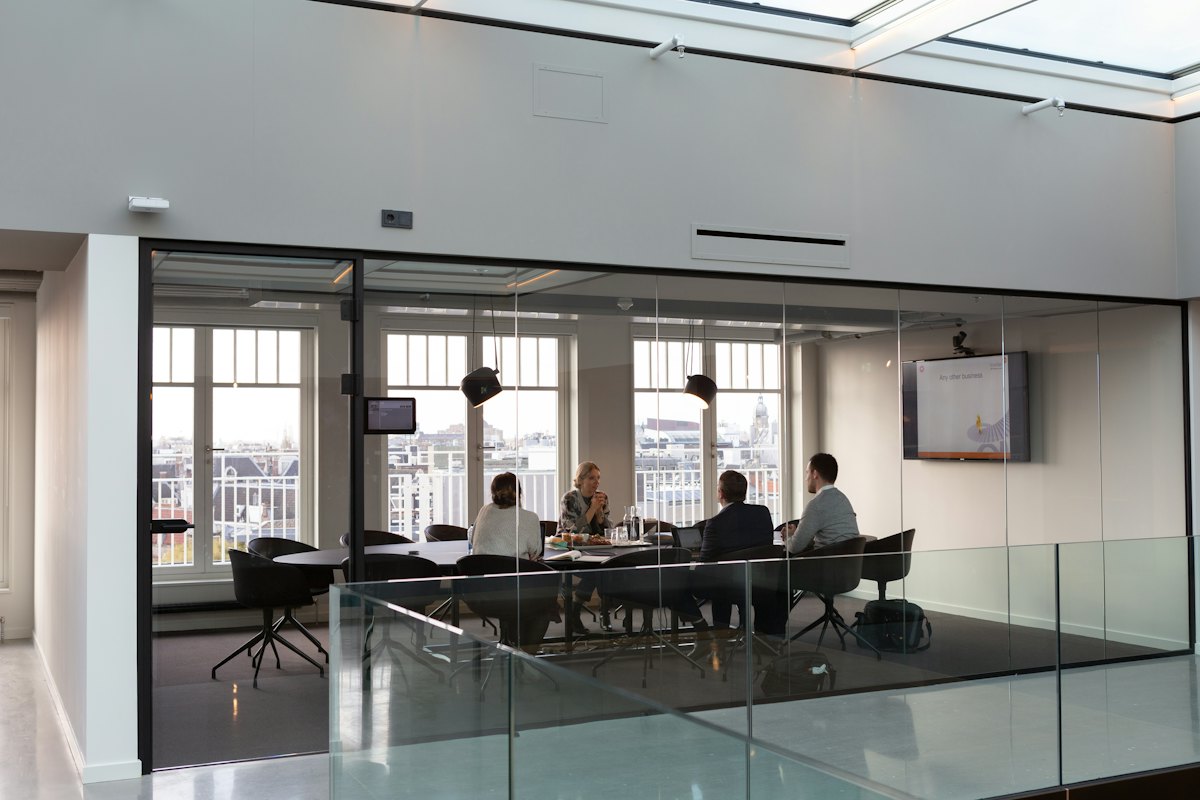 Management team meeting in a bright glass-walled conference room