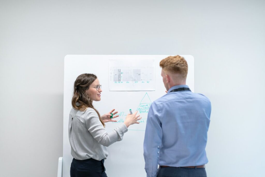 Two colleagues mapping out growth plans on a whiteboard